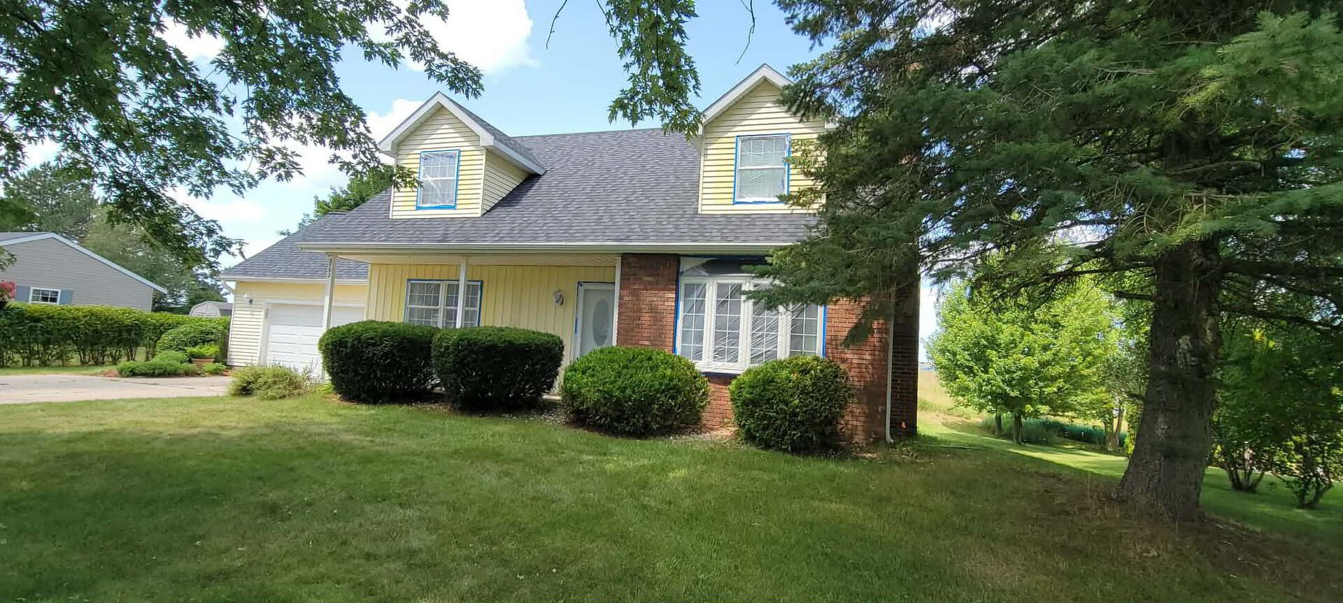 The same house with yellow siding and masked windows during preparation