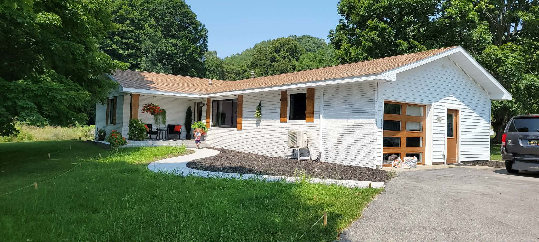 White home exterior with natural wood shutters and garage door